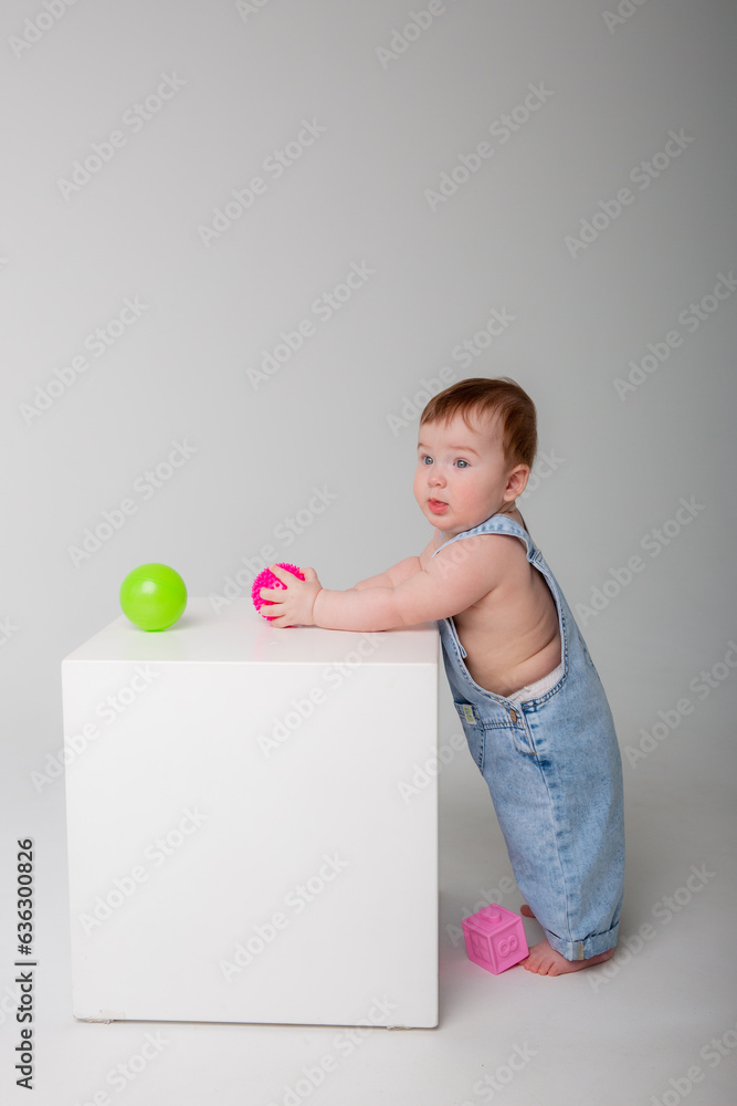 baby boy on a white background playing with colored balls baby boy on a white background playing with colored balls