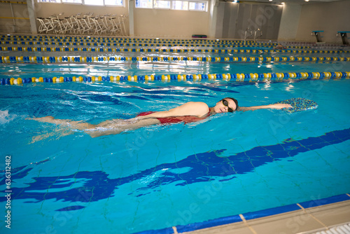 Young athlete practicing front crawl stroke in water photo