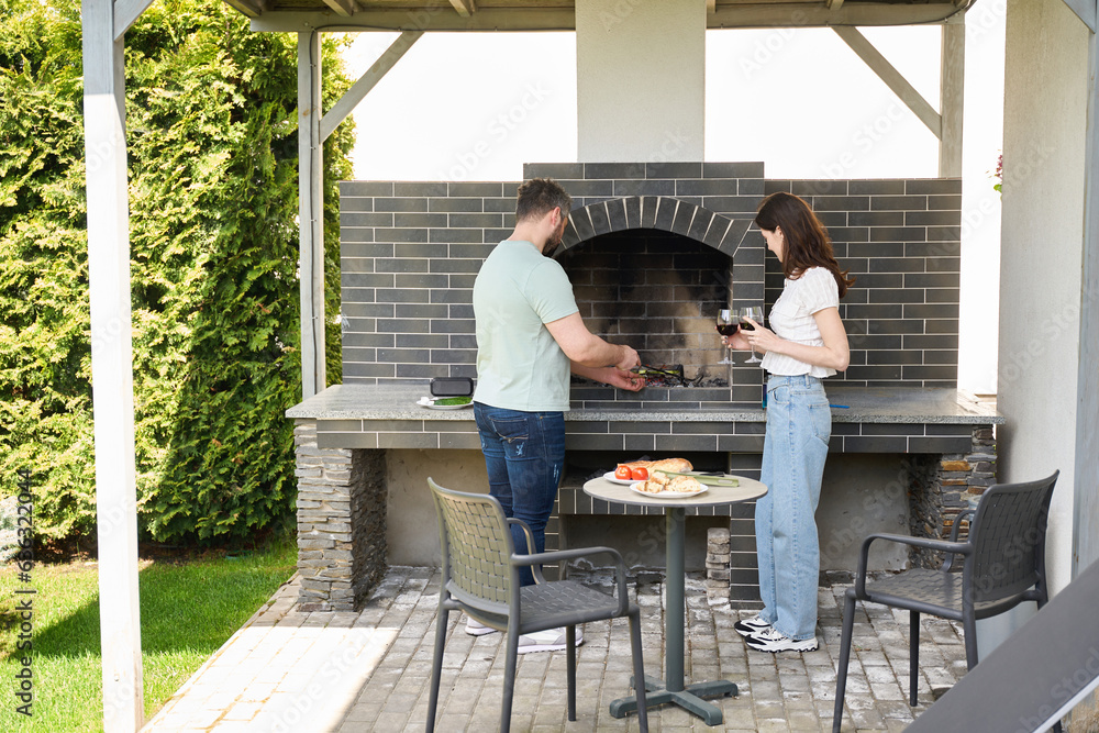 Middle-aged man in the yard cooks on coals Middle-aged man in the yard cooks on coals