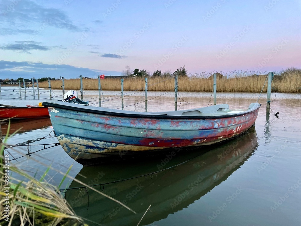 Old fishing boat, rowboat, dinghy in a small harbor. Beautiful sunset. Old fishing boat, rowboat, dinghy in a small harbor. Beautiful sunset.