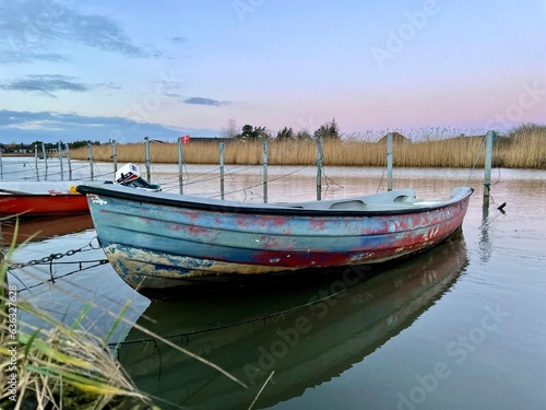 Old fishing boat  rowboat  dinghy in a small harbor. Beautiful sunset.