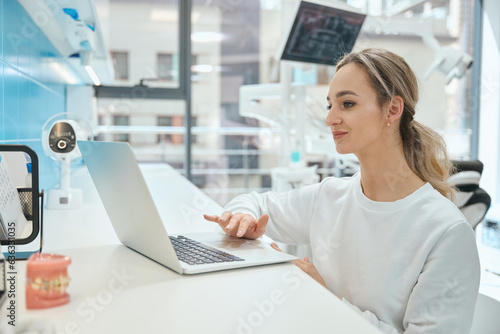 Woman physician working on laptop in the hospital