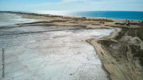 The shore of the salt lake. Sand covered with salt. Texture. A rare natural phenomenon.