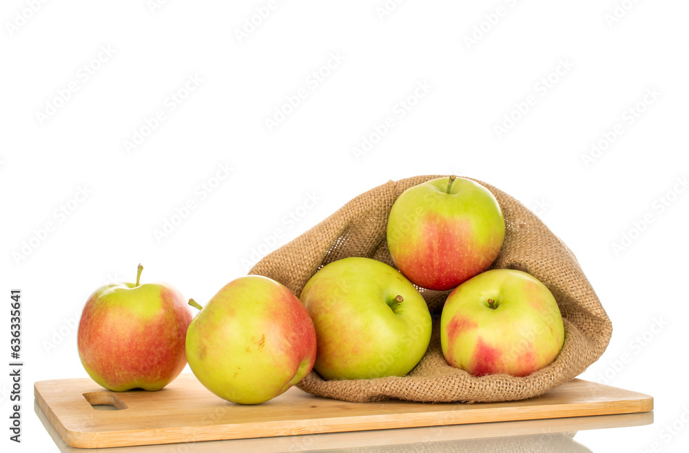 Several sweet juicy apples in a jute bag and on a bamboo kitchen board, macro, isolated on white background. Several sweet juicy apples in a jute bag and on a bamboo kitchen board, macro, isolated on white background.