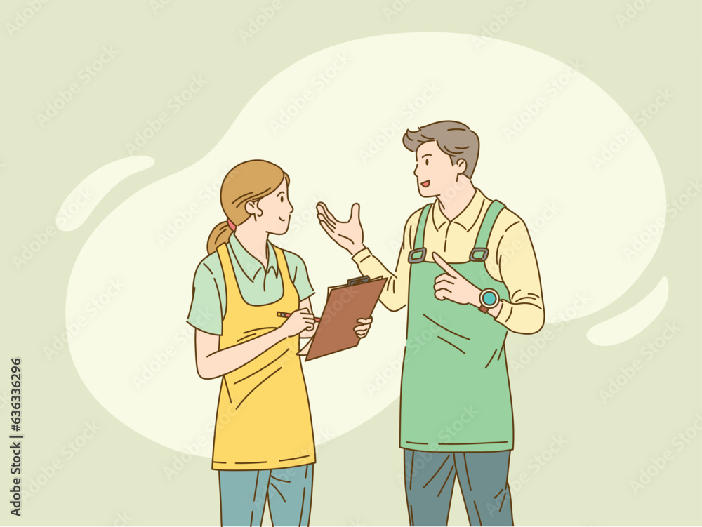 Woman in apron with clipboard speaks with man in apron. Woman in apron with clipboard speaks with man in apron.