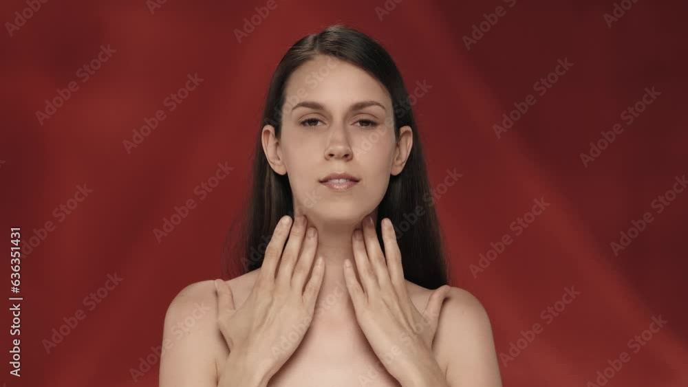 A woman demonstrates her perfect skin and regular facial features. Portrait of a seminude woman on a red background close up. The concept of natural beauty, plastic surgery, cosmetology, care. A woman demonstrates her perfect skin and regular facial features. Portrait of a seminude woman on a red background close up. The concept of natural beauty, plastic surgery, cosmetology, care.