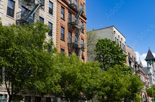 Row of Old Brick Residential and Apartment Buildings in East Harlem of New York City with Green Trees