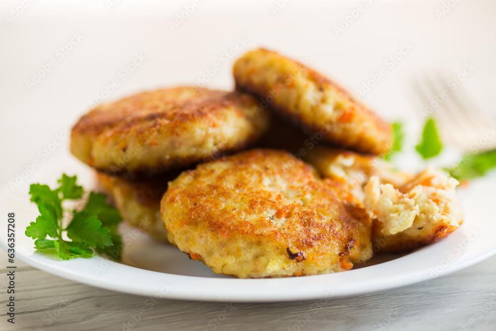 Cooked fried fish cutlets in a plate with herbs. Cooked fried fish cutlets in a plate with herbs.