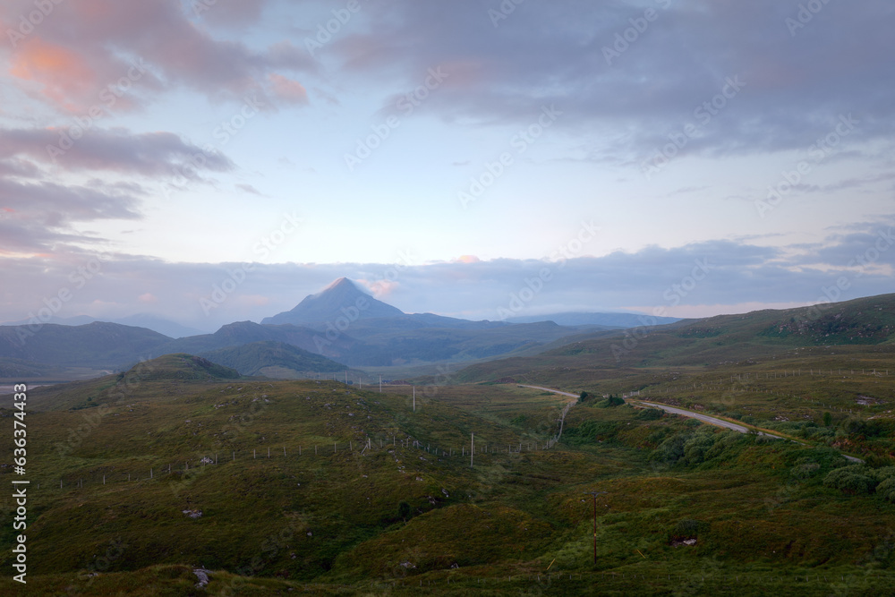 The western slope of Mount Ben Stack and the road through the valley at dawn. North West Sutherland, Scotland