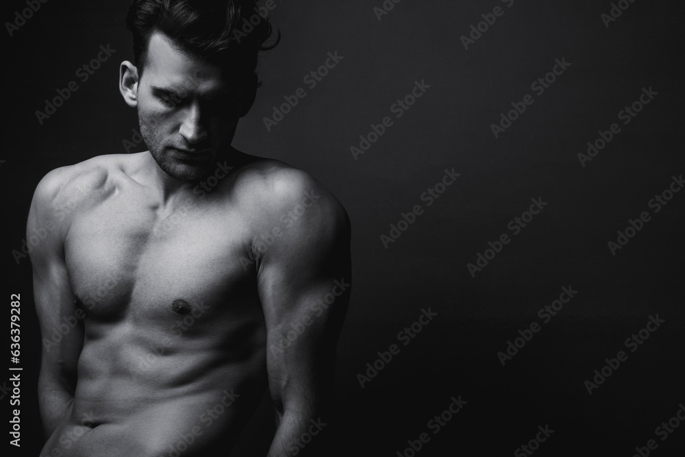 Naklejka premium Male beauty concept. Black and white portrait of handsome young man. Perfect hair and skin. Studio shot