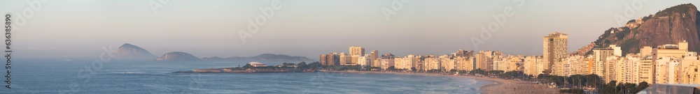 Rio de Janeiro, Brazil: aerial view in the pink light of the dawn of Copacabana beach, the city skyline with skyscrapers, the Copacabana Fort and the rocky hills full of vegetation