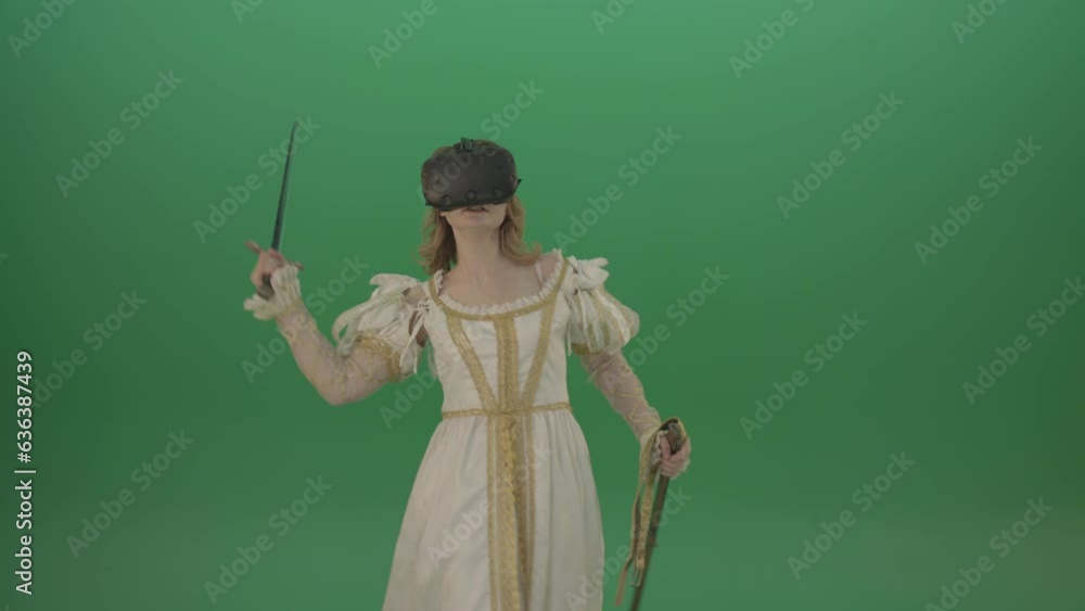 Girl in virtual reality has swallowed the world of adventures swinging with a sword isolated in green screen studio Girl in virtual reality has swallowed the world of adventures swinging with a sword isolated in green screen studio