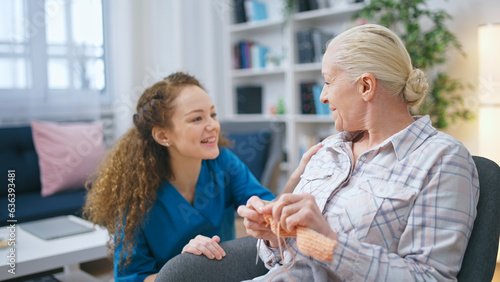 A young nurse visits a senior lady in a nursing home, inquiring about her well-being
