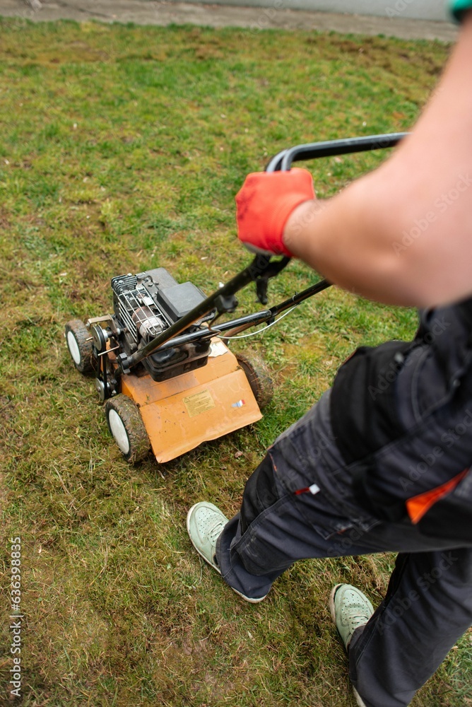 the young boy is working with his lawn mower outside the young boy is working with his lawn mower outside