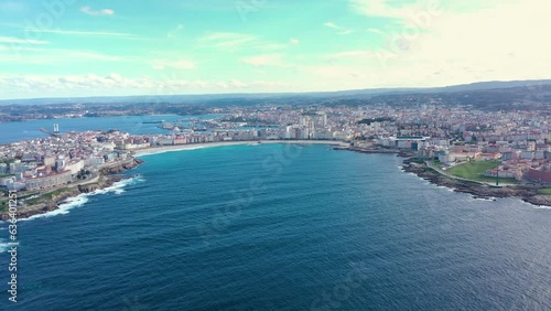 Aerial drone view of A Coruna, Galicia, Spain. Drone forward above de bay. In front are the two main beaches of A Coruna, Riazor and Orzán Beach. In background is the port area of the city. Travel. photo