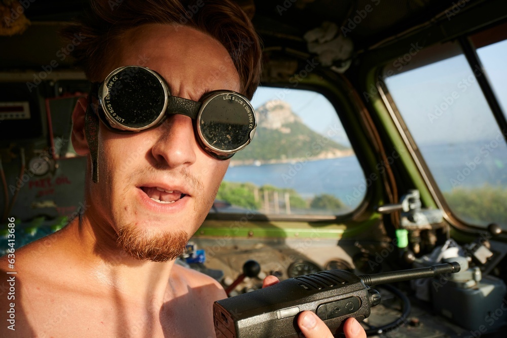Φωτογραφία Caucasian man wearing sunglasses and no shirt while casually sitting in a boat i