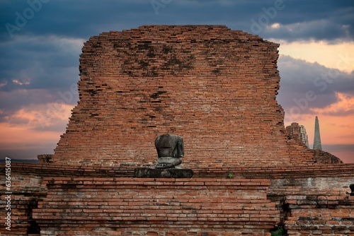 Photography Ancient brick wall with an old headless Buddha statue