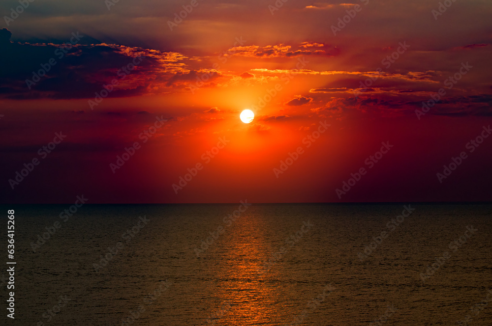 Beach of the ocean and red sun rise.