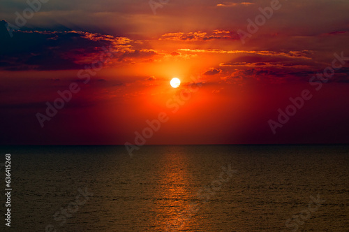 Beach of the ocean and red sun rise.