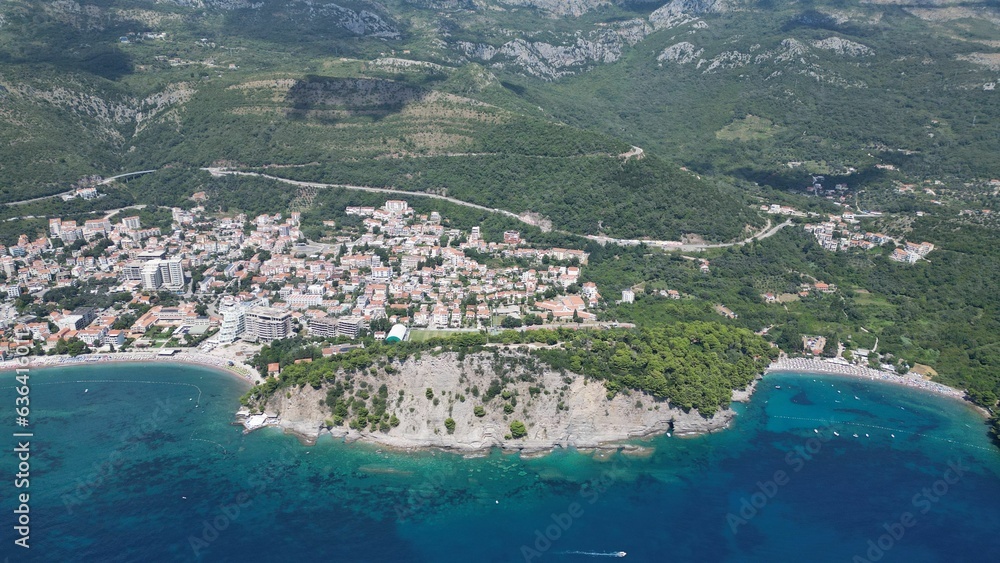 Aerial view of a lush green mountainous island surrounded by clear waters in Petrovac, Montenegro