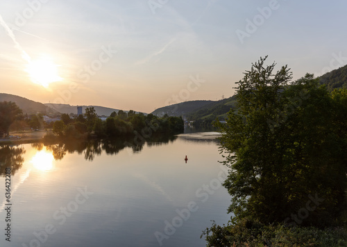 Fototapeta Naklejka Na Ścianę i Meble -  Hassmersheim across the river Neckar in the direction of Hornberg Castle with water reflections