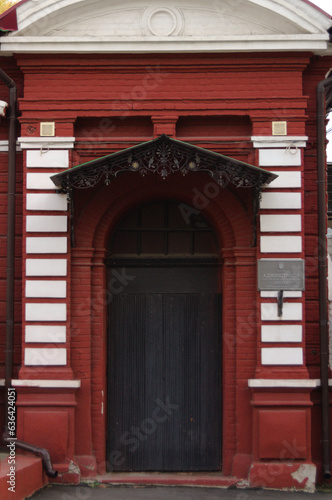 old dark door of a red and white building with patterns © Bezelord