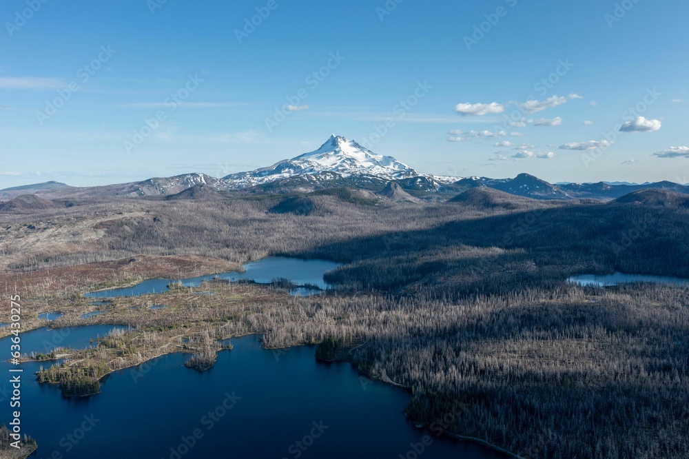 Areal view of a tranquil glacial lake surrounded by snow-capped mountains in the background Areal view of a tranquil glacial lake surrounded by snow-capped mountains in the background