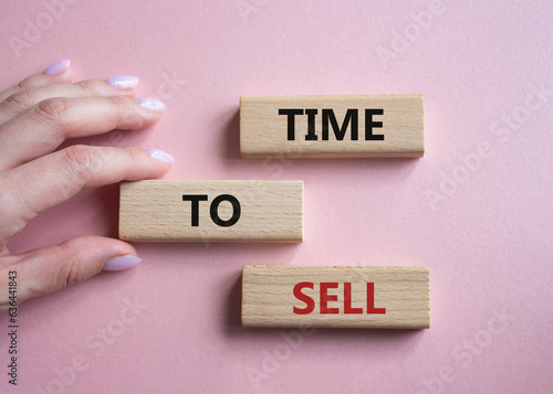 Time to Sell symbol. Concept words Time to Sell on wooden blocks. Businessman hand. Beautiful pink background. Business and Time to Sell concept. Copy space.