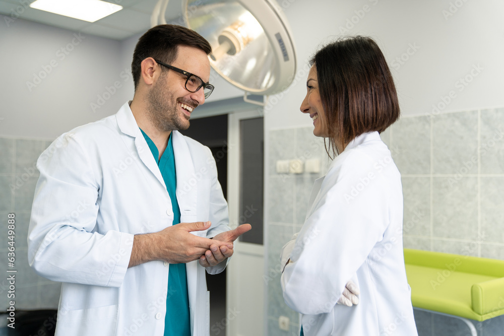 Fototapeta premium Two adult happy and cheerful medical professionals male and female doctors having discussion in operating theatre in private hospital.