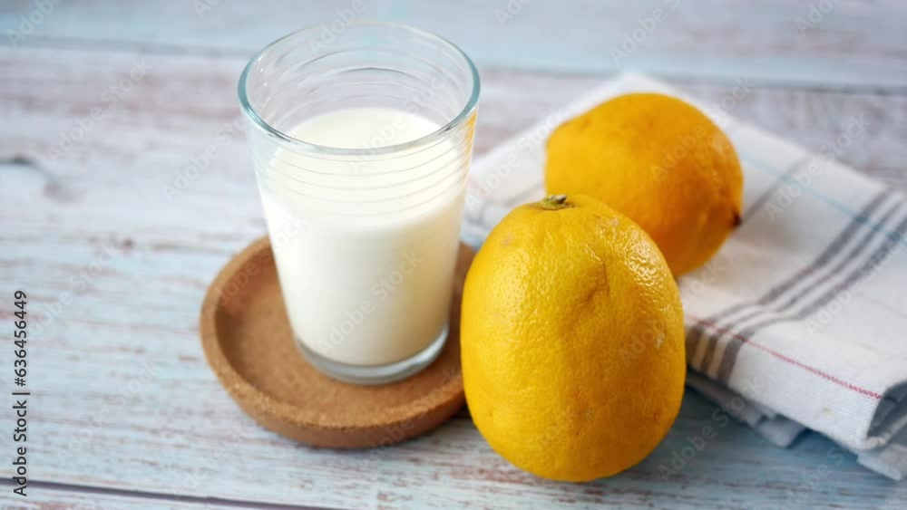 Yellow Lemon and glass of milk on table Yellow Lemon and glass of milk on table
