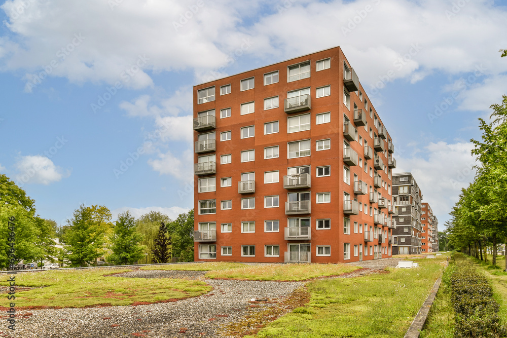an apartment building on the side of a road with green grass and trees in the fore - eyed photo is taken an apartment building on the side of a road with green grass and trees in the fore - eyed photo is taken