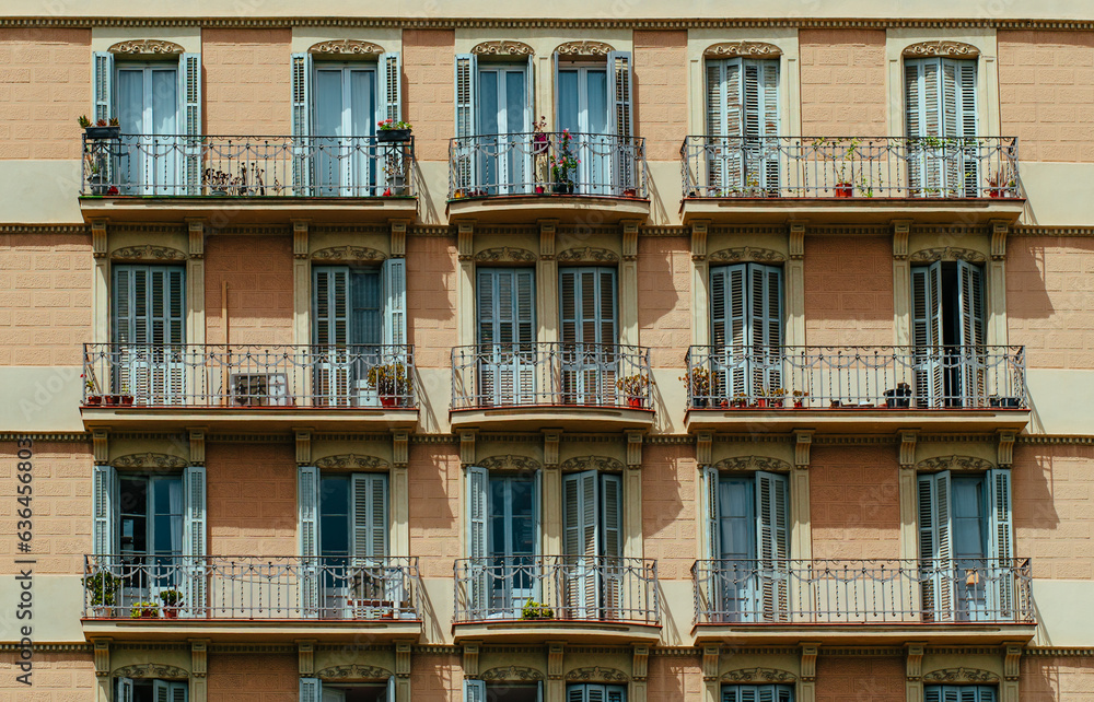 Exterior of traditional residential house with balconies and wooden shutters on the windows in European city