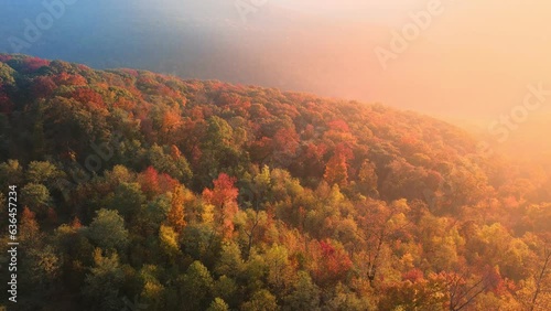 Foggy sunrise drone aerial over autumn Arkansas ozark mountains with colorful fall forest trees
