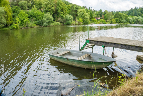 Wooden boat on the calm surface of the river Berunka near Zadni Treban island.