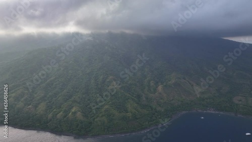 Clouds drift above the rainforest covering Pulau Sangeang, a volcano near Komodo National Park. This is a popular island to visit for scuba divers as it is home to extraordinary marine biodiversity. photo