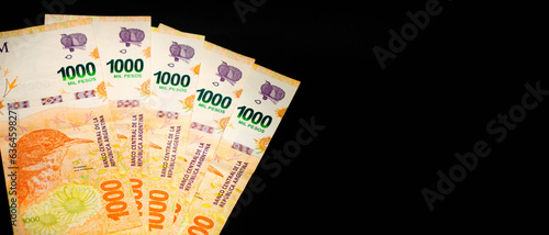 Banknotes of 1000 Argentine pesos, Argentine money, Argentine currency, Argentine pesos. Pile of several thousand Argentine peso bills, one thousand peso bills in cash on black background photo