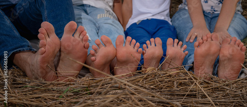 Close-up of the legs of a family of two adults and two children outdoors in a Ukrainian wheat field, family legs