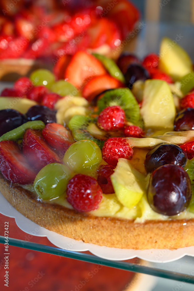 French fresh baked sweet pastry with fresh red summer fruits and berries in confectionery shop close up French fresh baked sweet pastry with fresh red summer fruits and berries in confectionery shop close up