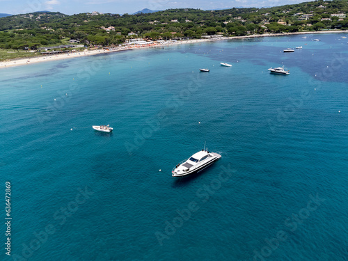 Aerial view on boats, crystal clear blue water of legendary Pampelonne beach near Saint-Tropez, summer vacation on white sandy beach of French Riviera, France © barmalini