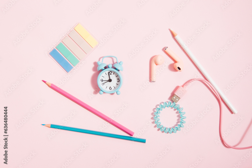 Back to school - alarm clock and pencils, headphones and stationery on pink background, girly set as education concept Back to school - alarm clock and pencils, headphones and stationery on pink background, girly set as education concept