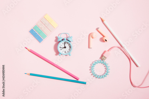 Back to school - alarm clock and pencils, headphones and stationery on pink background, girly set as education concept