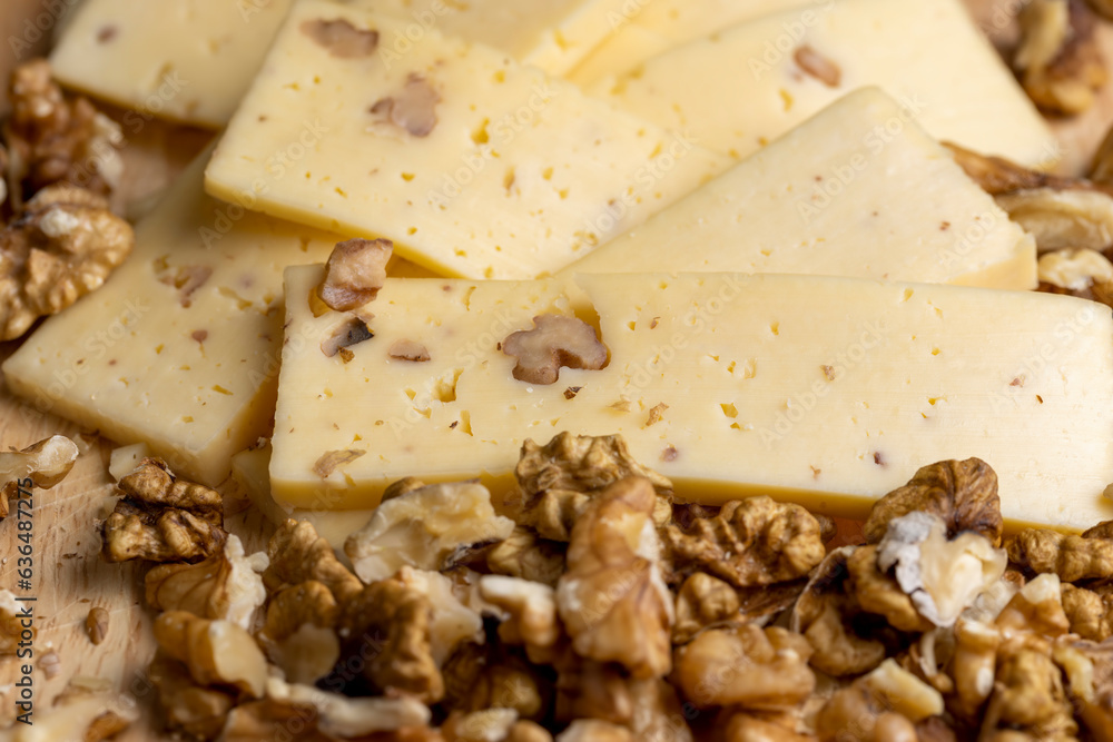 Sliced piece of milk cheese with walnuts Sliced piece of milk cheese with walnuts