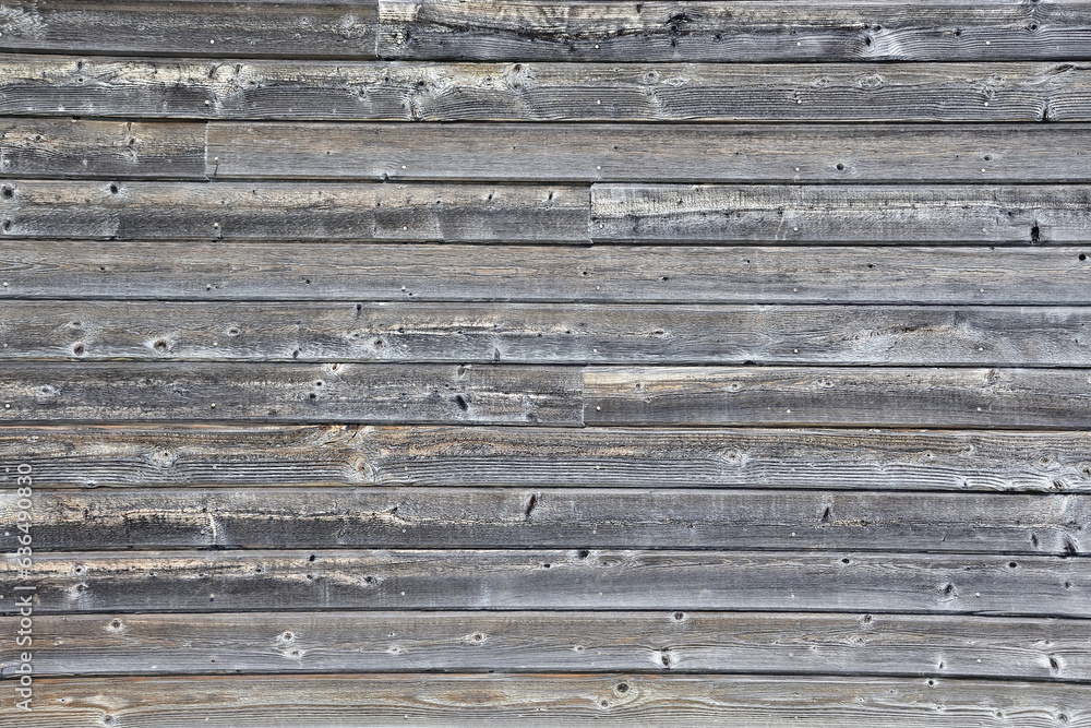 Weathered wood board on barn wall. Background of greyish wood plank Weathered wood board on barn wall. Background of greyish wood plank