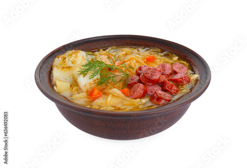 Bowl of delicious sauerkraut soup with smoked sausages, dill and croutons isolated on white