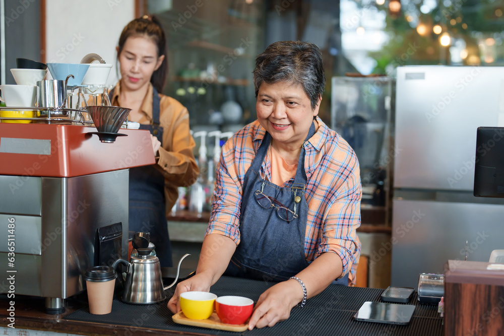 Elderly woman holds wooden tray with hot coffee mugs on it, waiting for