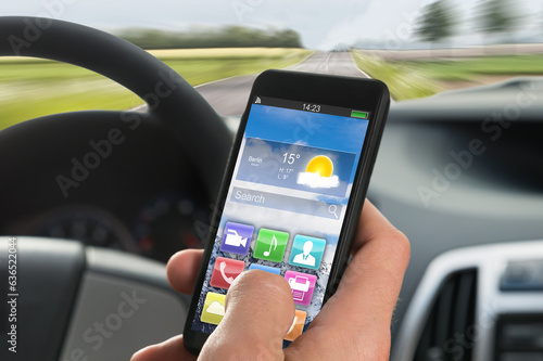 Person's Hand Using Cellphone While Driving A Car