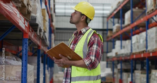 Asian man Checking stock in big warehouse