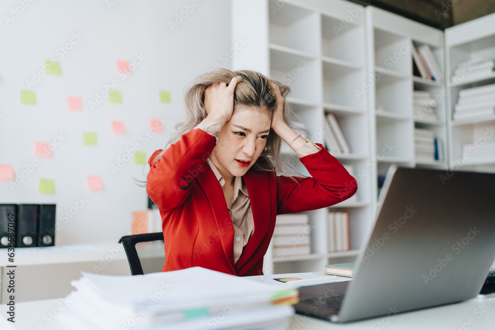 Portrait of business owner, woman using computer and financial statements Anxious expression on expanding the market to increase the ability to invest in business Portrait of business owner, woman using computer and financial statements Anxious expression on expanding the market to increase the ability to invest in business