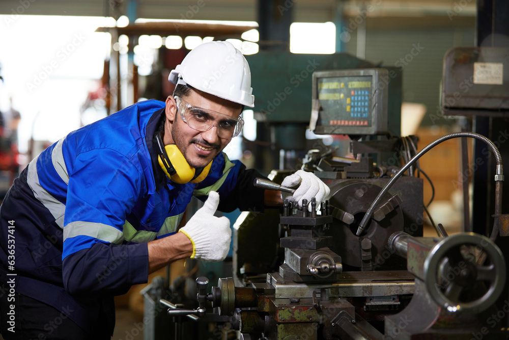 factory worker or technician smiling and thumbs up pose beside lathe machine in factory factory worker or technician smiling and thumbs up pose beside lathe machine in factory