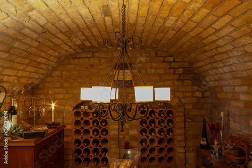 Wine cellar with vaulted ceiling and candle chandelier photo